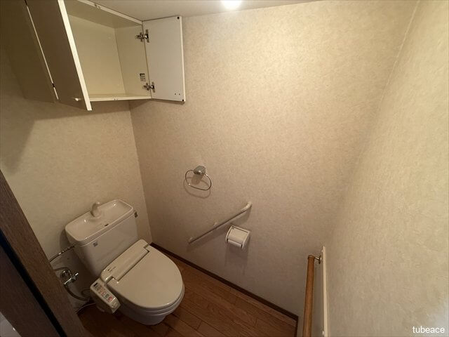 清潔感のあるトイレ空間。上部に収納棚も備えています。